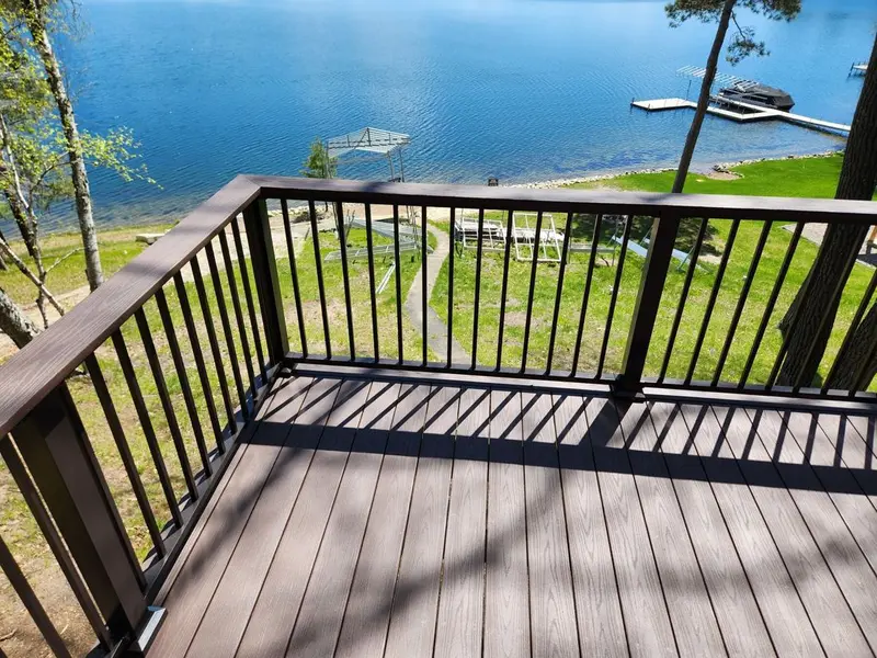 Composite lake deck with black aluminum railing overlooking the water