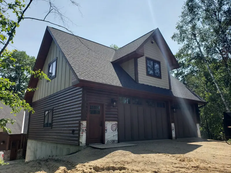 Log siding and board-and-batten on a new garage by Tri-County Professional Builders