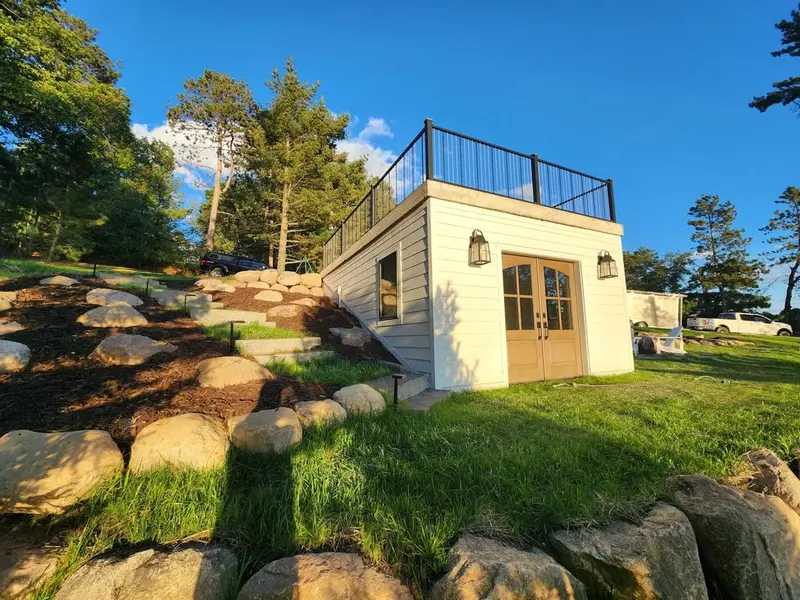 Lakeside boathouse with rooftop deck by Tri-County Professional Builders