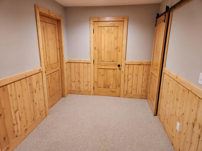 Finished lower-level room with knotty pine wainscoting and new carpet